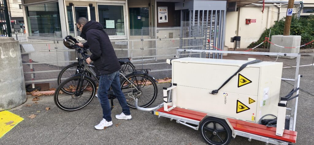 Photo d'un repreneur venant récupérer des matériaux de réemploi à vélo sur le chantier de Boehringer Ingelheim à Lyon